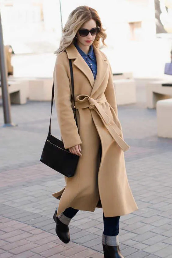 belted camel coat with cuffed jeans and boots
