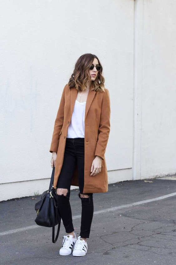 black jeans and white sneakers and camel coat